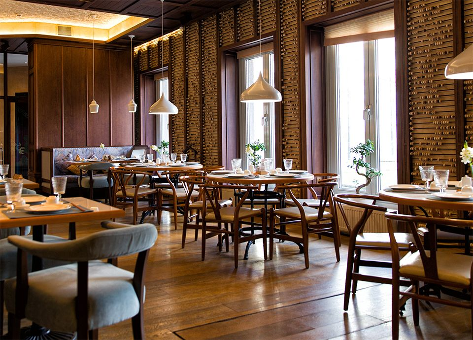 Contemporary restaurant dining area with wooden ceiling and pendant lights