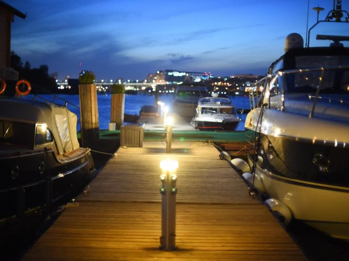 Commercial dock with security lighting illuminating vessel mooring area