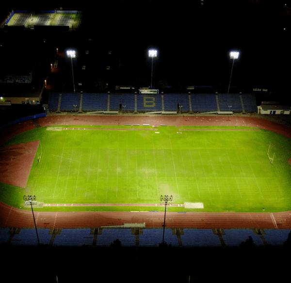 Commercial Sports & Stadium Lighting: Why Major Projects Are Ditching Metal Halide for LED Aerial view of Wightman Stadium at night with LED floodlights illuminating the football field and running track