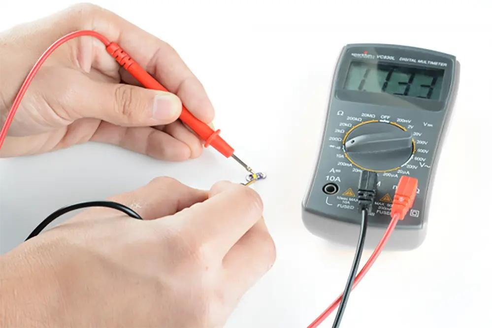 LED Power Factor: The Invisible Spec That's Silently Costing Your Commercial Project Thousands Electrician testing LED fixture with multimeter for power quality