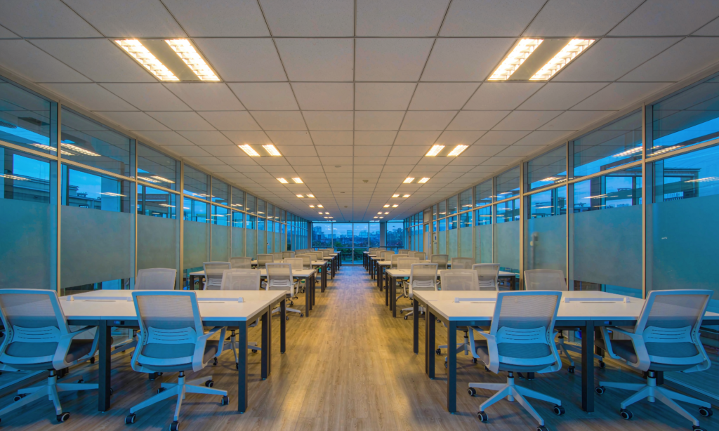 Recessed LED troffer panels lighting a modern open-plan office at dusk
